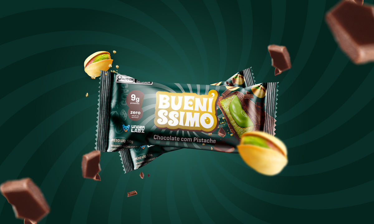 Embalagem da barra Bueníssimo Chocolate com Pistache em destaque, com pistaches e pedaços de chocolate ao redor sobre fundo verde.
